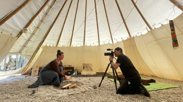 Woman preparing firewood in front of a camera