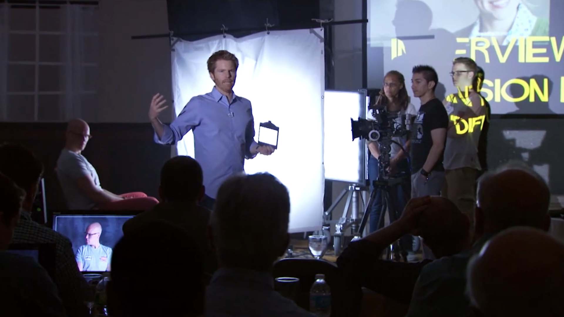 Alex Buono in the class showing the practical example of lighting the interview setup and using a lens filter