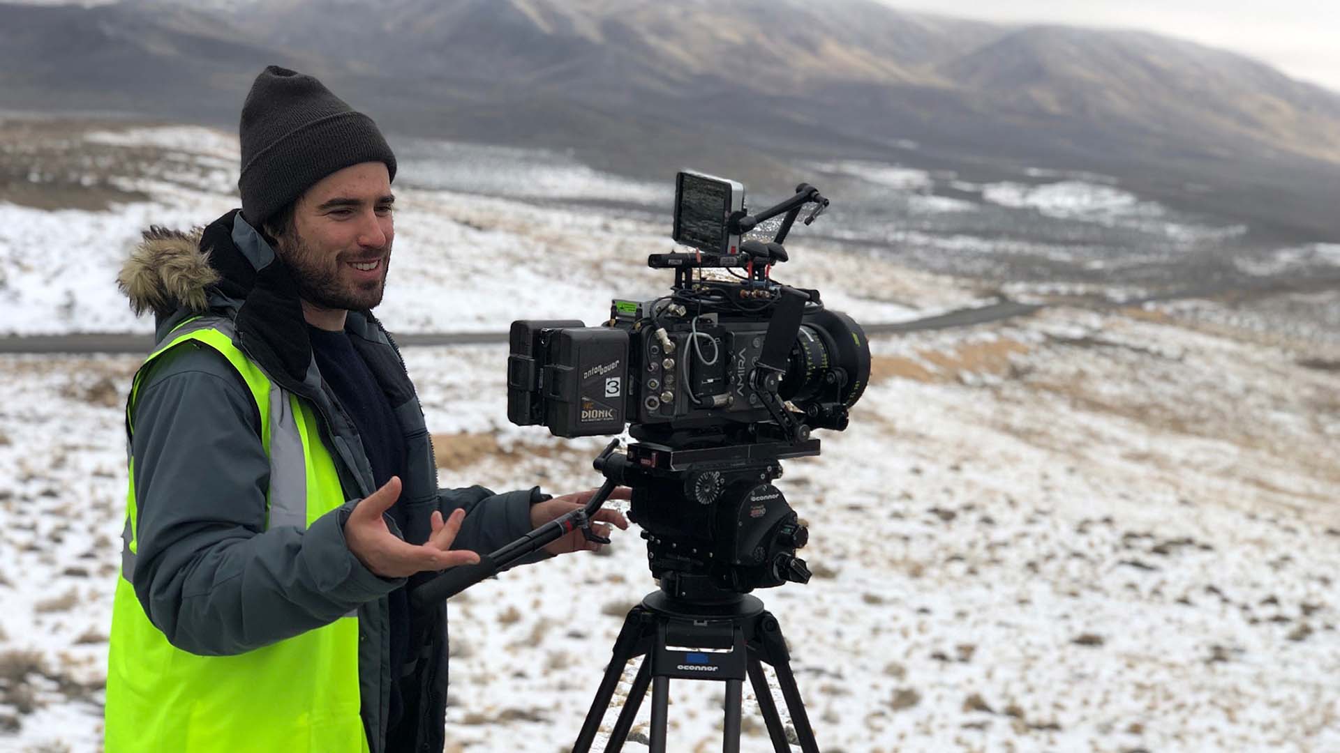 photo of the Nomadland's cinematographer, showing him, the camera on a tripod, and the snowy landscape in the background