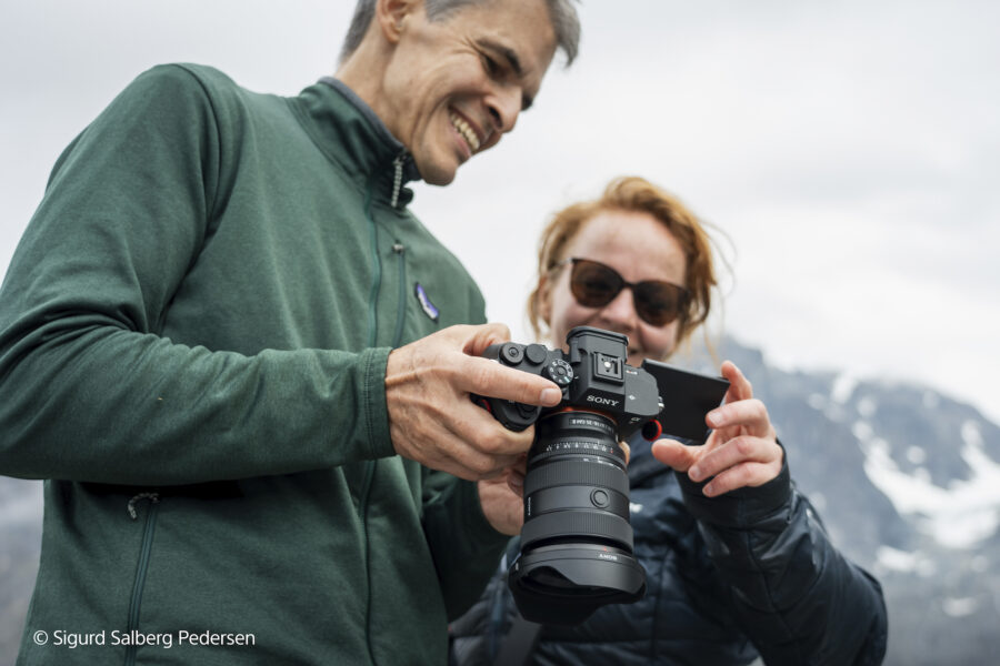 two people holding a camera with a Sony FE 16-35mm F2.8 GM II lens